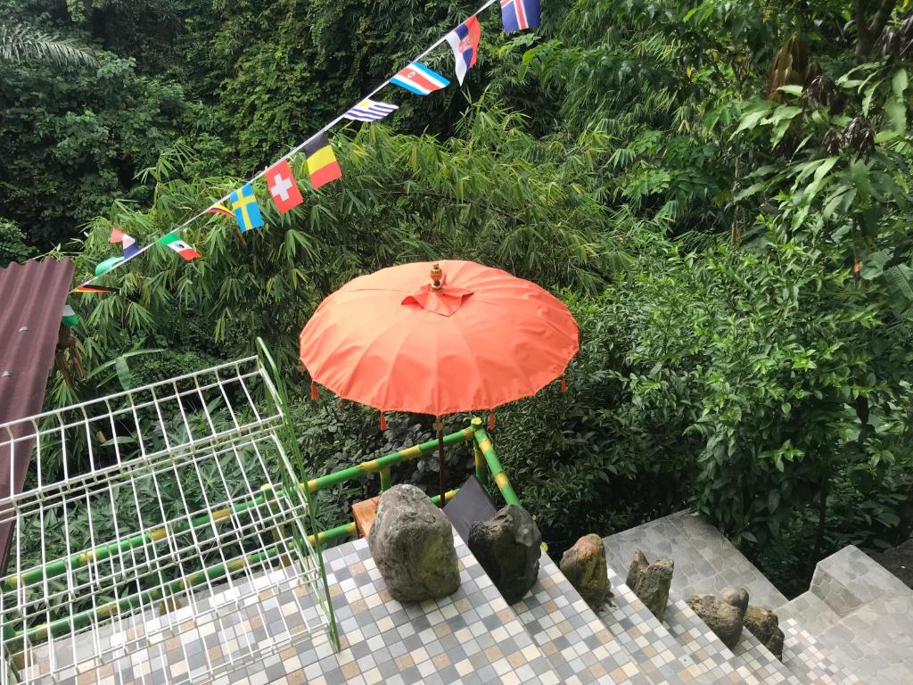 an orange umbrella sitting on the stairs with flags at WW Backpackers in Ubud
