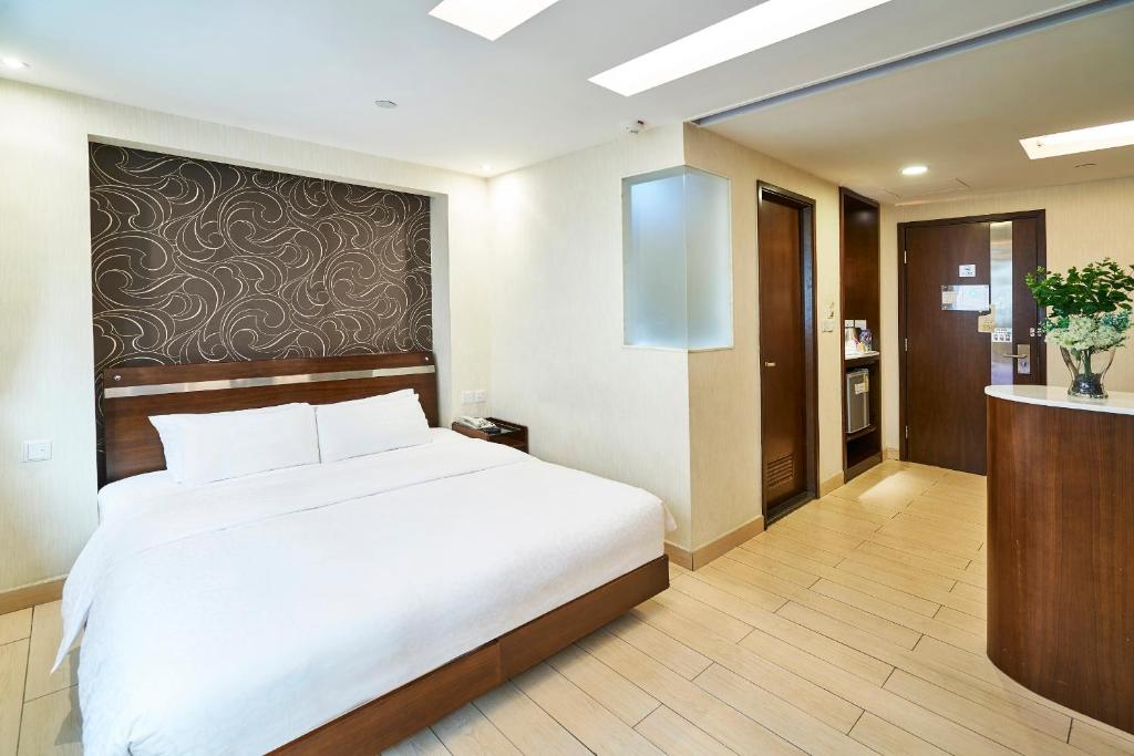 um quarto com uma grande cama branca em um quarto em Pop Inn Mong Kok em Hong Kong