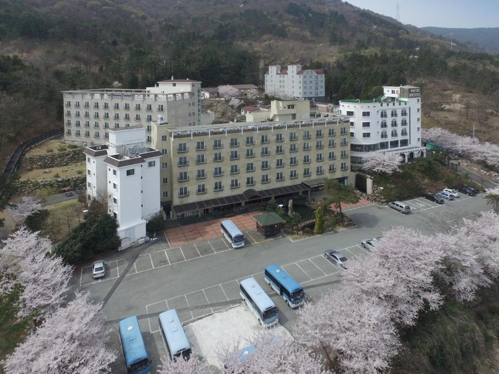 un gran edificio con coches estacionados en un estacionamiento en Geoje Oasis Hotel, en Geoje