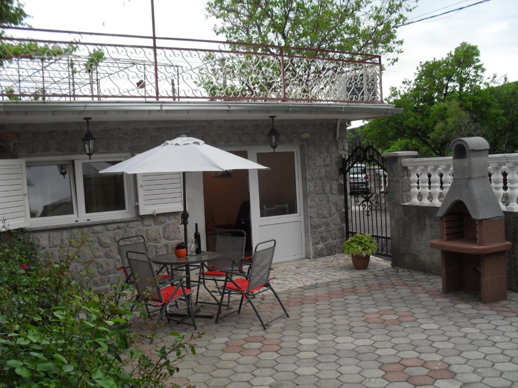 eine Terrasse mit einem Tisch, Stühlen und einem Sonnenschirm in der Unterkunft Apartman Jurja in Ledenice