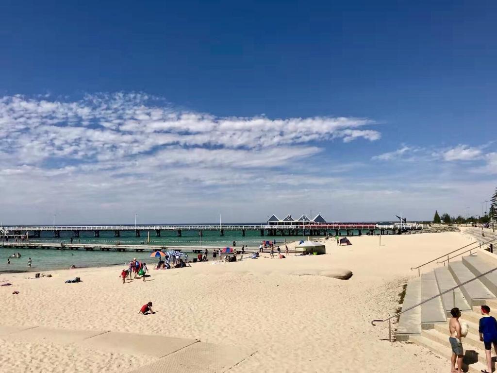 a group of people on a beach with a pier at Little Shangri-La in Busselton