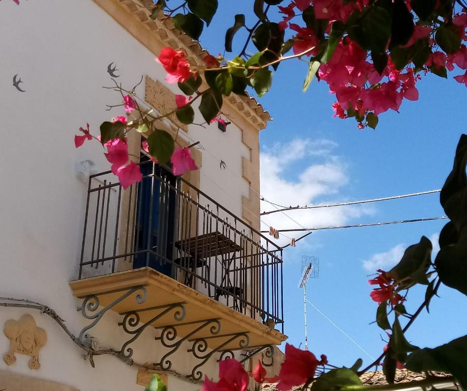 - un balcon sur le côté d'un immeuble fleuri dans l'établissement Dimore Sicule Noto, à Noto