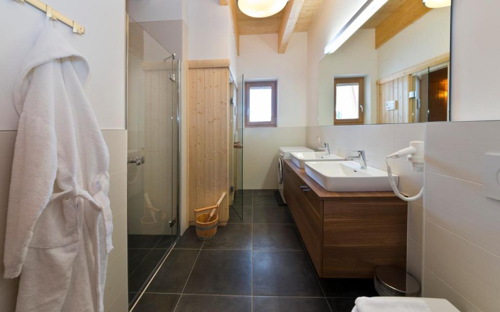 łazienka z 2 umywalkami i prysznicem w obiekcie Apartments Dolomit-Royal w mieście Sillian