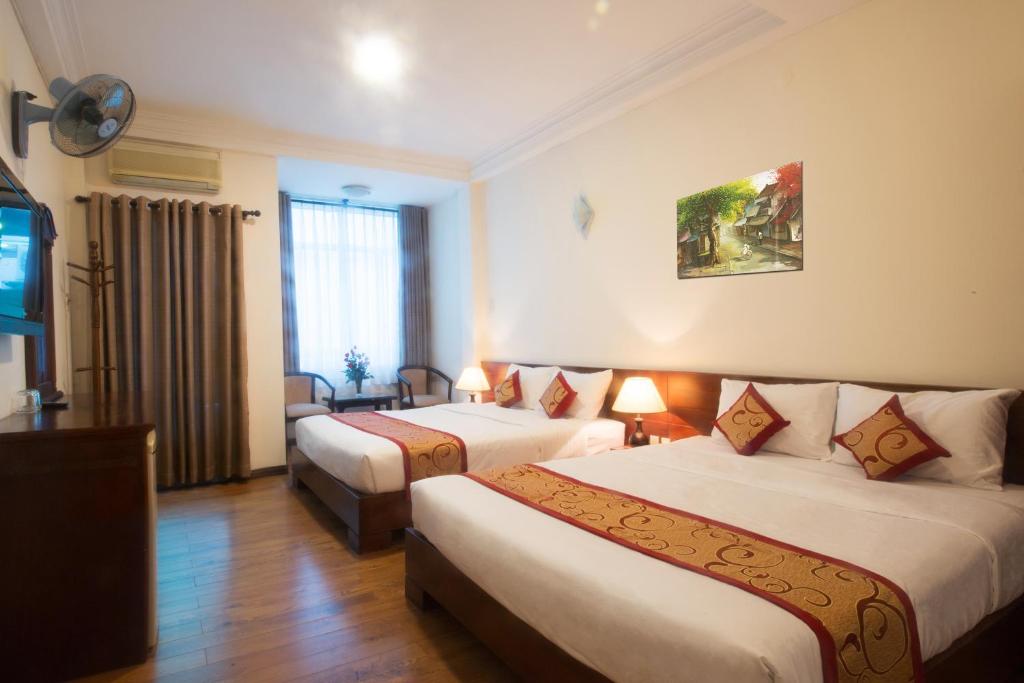 ein Hotelzimmer mit 2 Betten und einem TV in der Unterkunft Ngoc Minh Hotel in Ho-Chi-Minh-Stadt