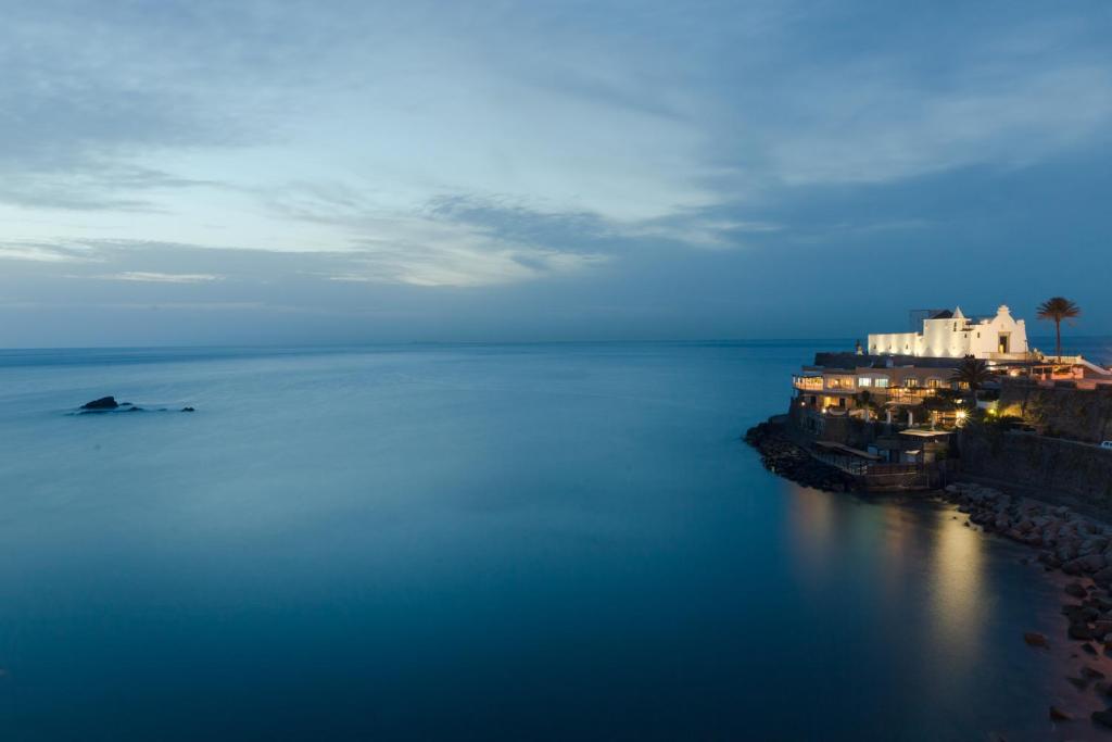una vista de un gran cuerpo de agua por la noche en Hotel Umberto A Mare, en Isquia