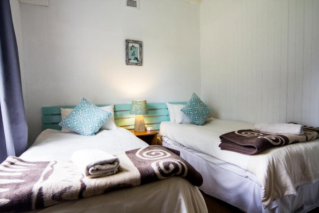 two beds in a room with towels on them at 40 Fraser Street Bed and Breakfast in Howick