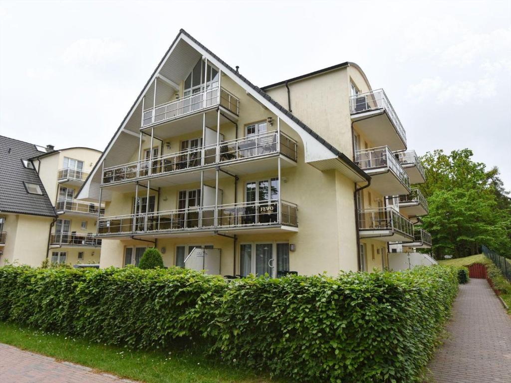 an apartment building with balconies and a hedge at Ferienwohnung-1a-7 in Baabe