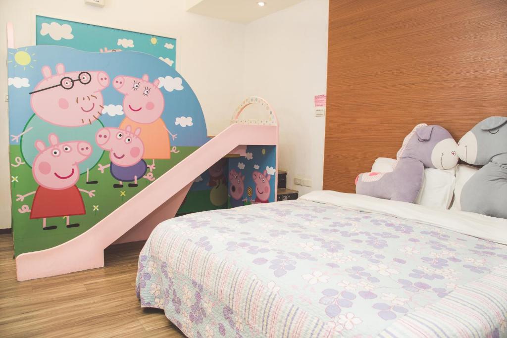 a childs bedroom with a bed and a mural of pigs at Happy Castle Cottage in Hualien City