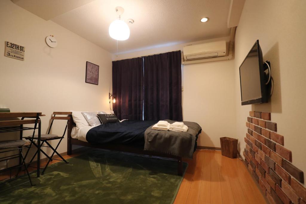 una camera con letto e TV di Hotel Yumeya a Fukuoka