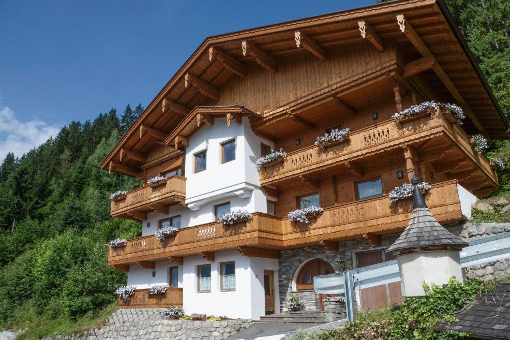 a building with a wooden roof on a mountain at Haus Barbara in Zell am Ziller