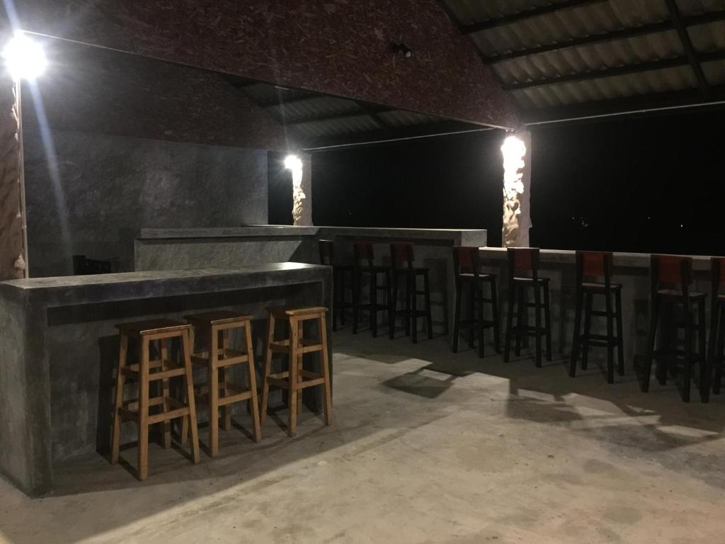 a bar with stools in a room with lights at Nirvana Guesthouse & Hostel in Koh Tao