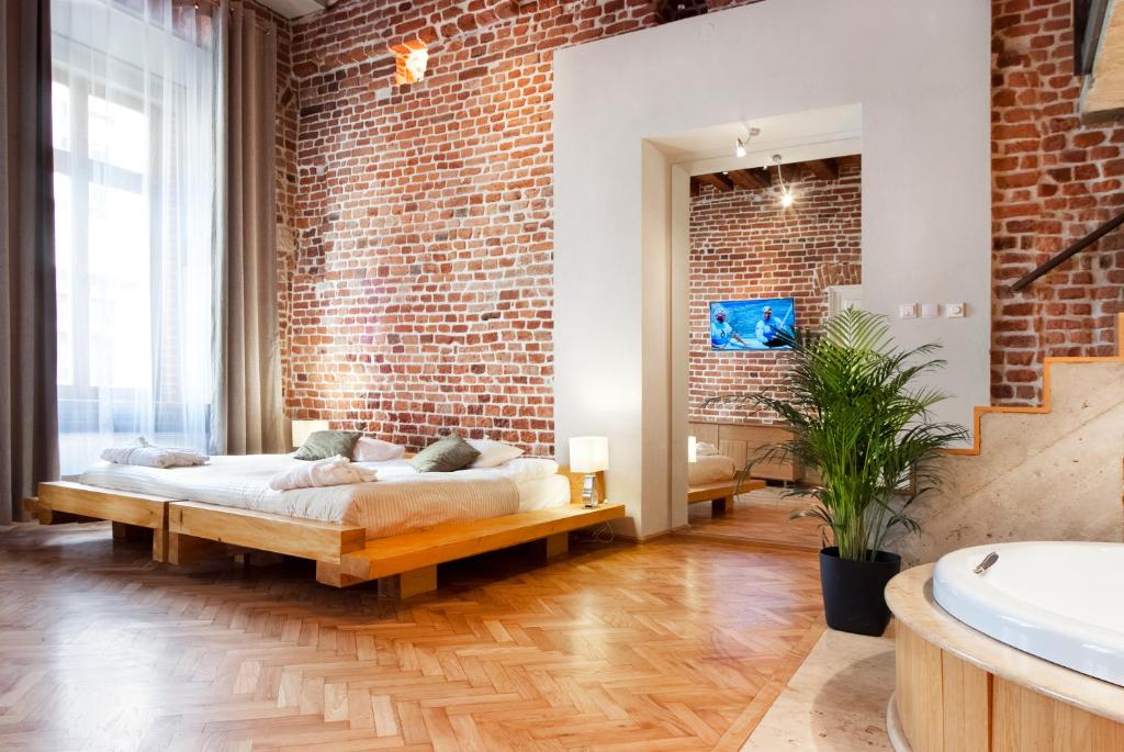 a bedroom with a bed and a brick wall at Aparthotel Stare Miasto in Kraków