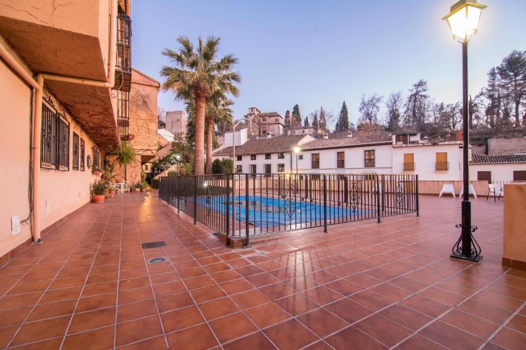 a courtyard with a pool and a street light at Casa de Alhacaba in Granada