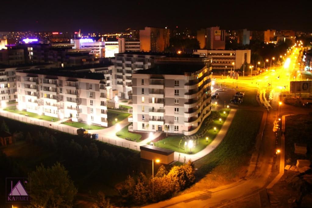uma cidade à noite com edifícios e luzes de rua em Kapart City em Rzeszów