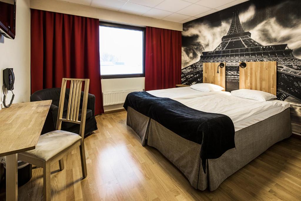 a bedroom with a large bed with a mural of a tower at Clarion Collection Hotel Bristol in Arvika