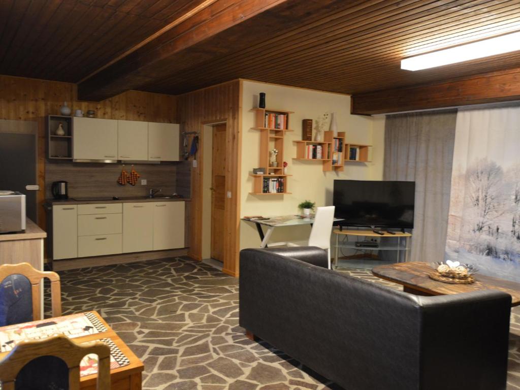 een woonkamer met een bank en een keuken bij Cozy Apartment in County of Manderscheid with TV in Manderscheid