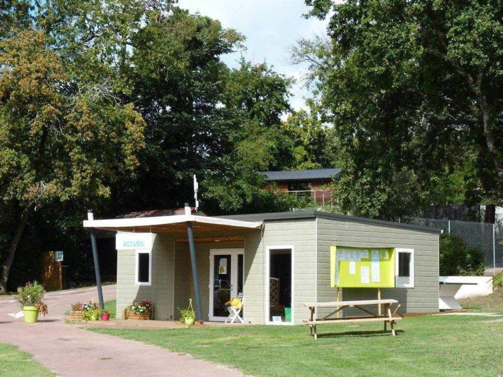 een klein huis met een veranda op het gras bij Camping Les Chênes Verts in Meschers-sur-Gironde