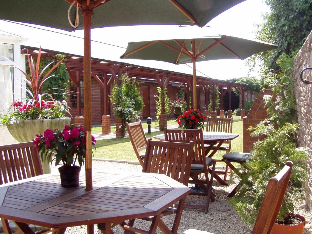 a table and chairs with an umbrella on a patio at Brandon Lodge in Hereford