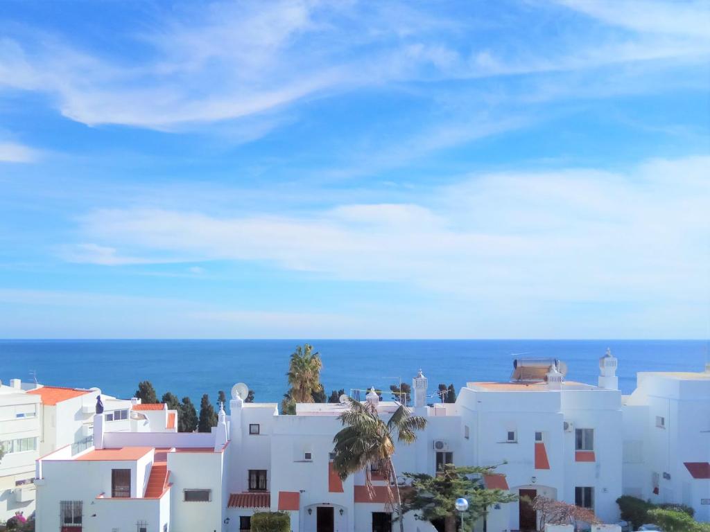 a group of white buildings with the ocean in the background at Apartamento de Praia - Albufeira in Albufeira