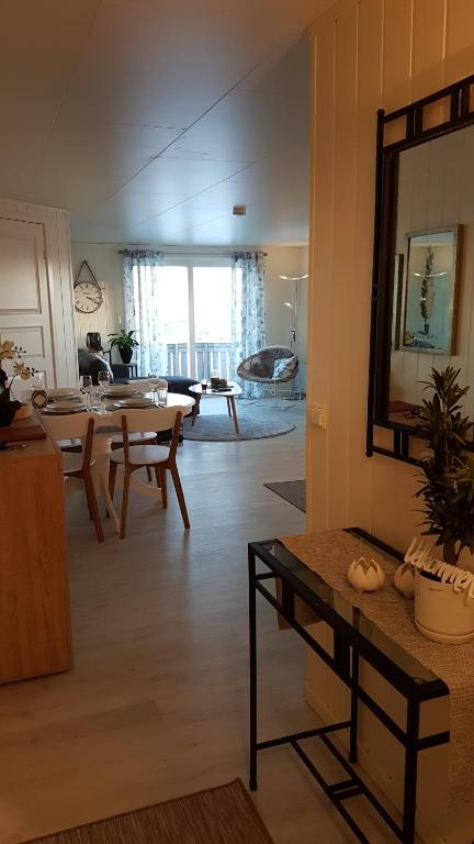 een woonkamer met een tafel en een spiegel bij Tore Hunds Apartments in Andenes