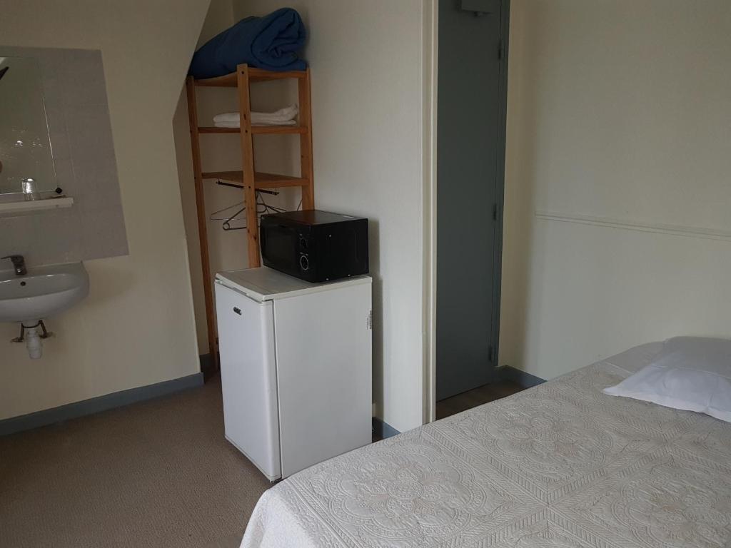a room with a small refrigerator with a speaker on it at Au Royal Mad in Paris