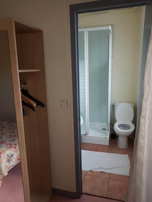 a bathroom with a toilet and a glass shower at Au Royal Mad in Paris