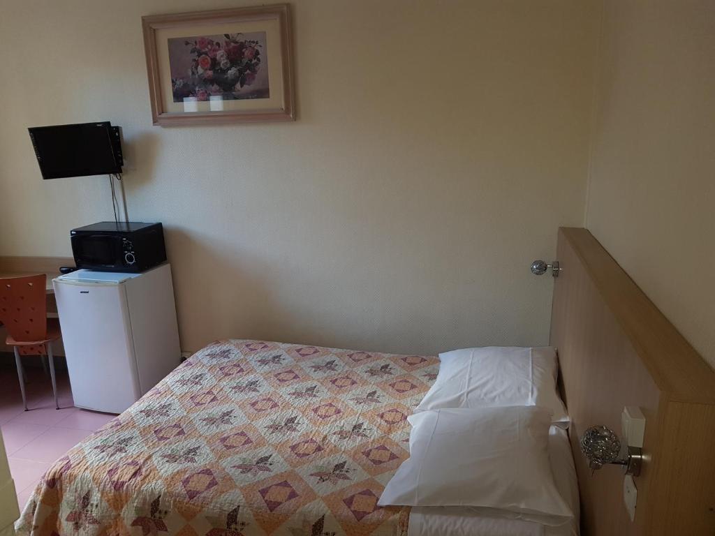 a small bedroom with a bed and a television at Au Royal Mad in Paris