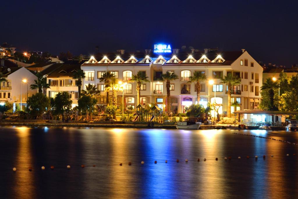 een hotel 's nachts naast een lichaam water bij Fora Apart Hotel in Datca