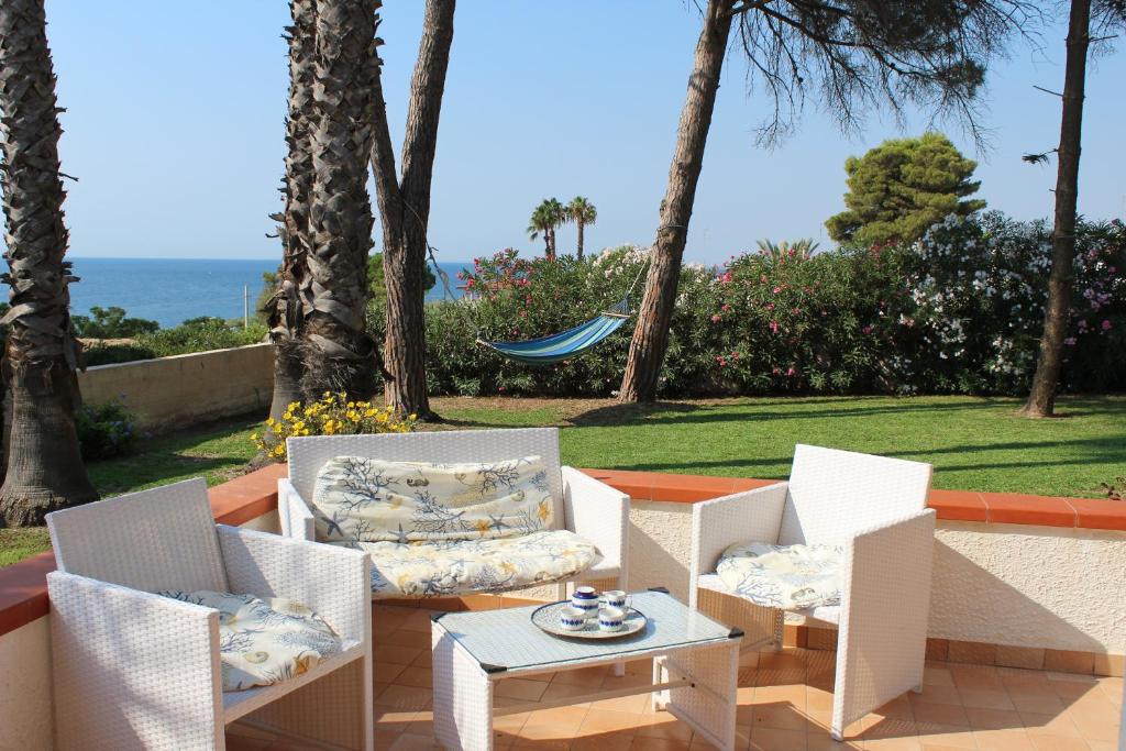 フォンターネ・ビアンケにあるVilla Mediterraneaの海を望むパティオ(白い椅子、テーブル付)