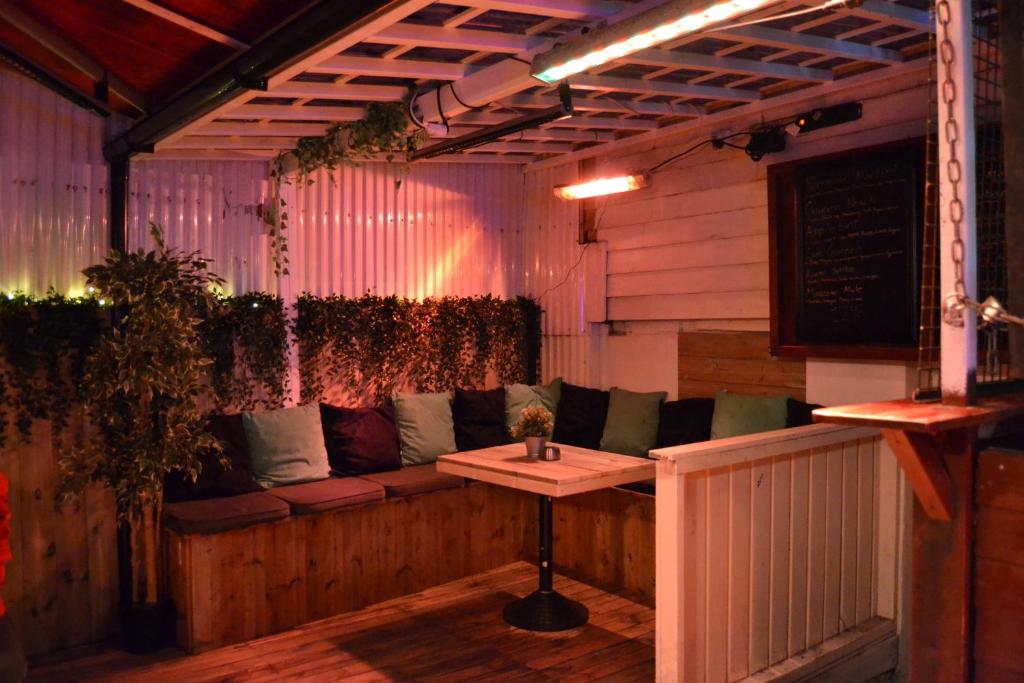 a bar with a couch and a table in a room at Skansen Hostel in Stavanger