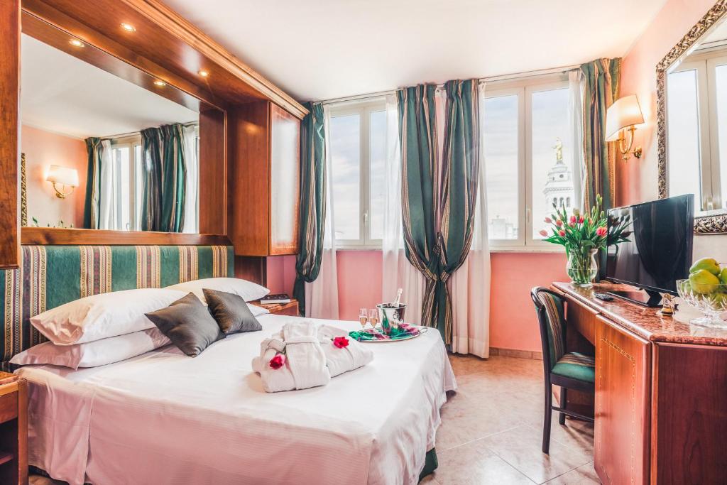 ローマにあるラエリ ホテル シラクーサのベッドとデスクが備わるホテルルームです。