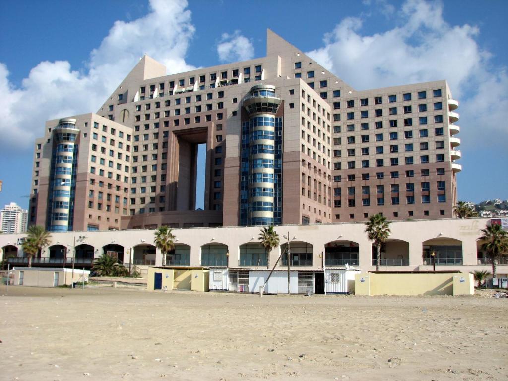 duży budynek z palmami przed nim w obiekcie Apartments on the Beach w mieście Hajfa