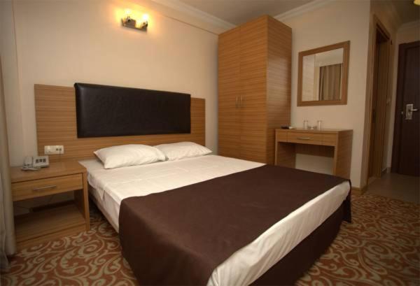 イスタンブールにあるLyon Hotel İstanbulの大きなベッドと鏡が備わるホテルルームです。