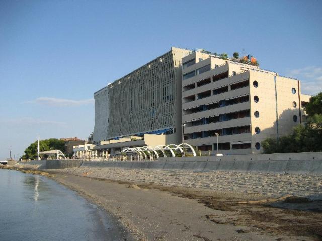 a large building next to a beach with a building at Appartamento Zipser II in Grado
