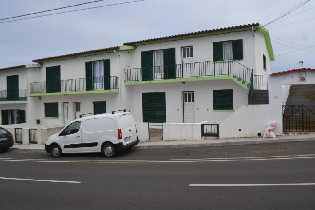 un furgone bianco parcheggiato di fronte a un edificio di TINA - AL Praia da Vitória - RRAL 759 a Praia da Vitória