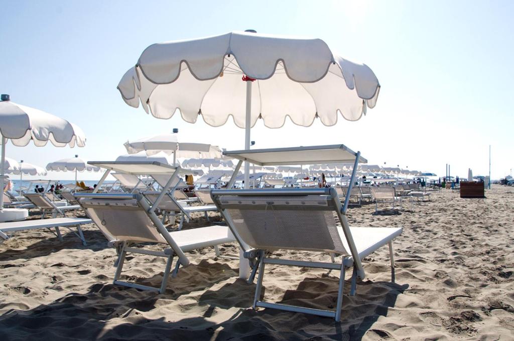 a group of chairs and umbrellas on a beach at Residence Terminus in Rimini