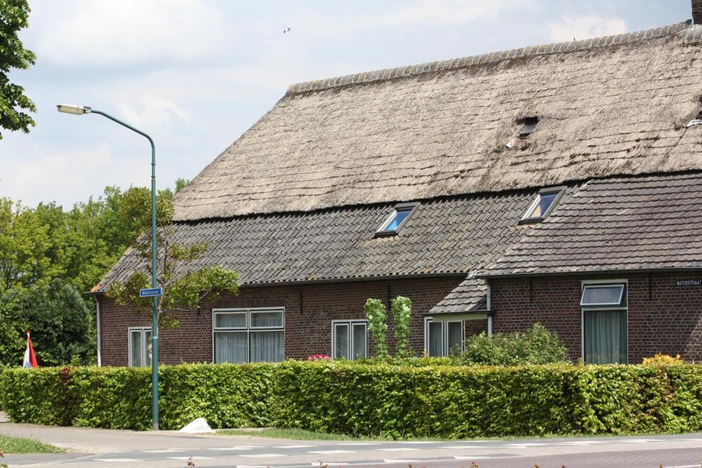 a brick house with a shingled roof at Logerenbijonsz in Berghem