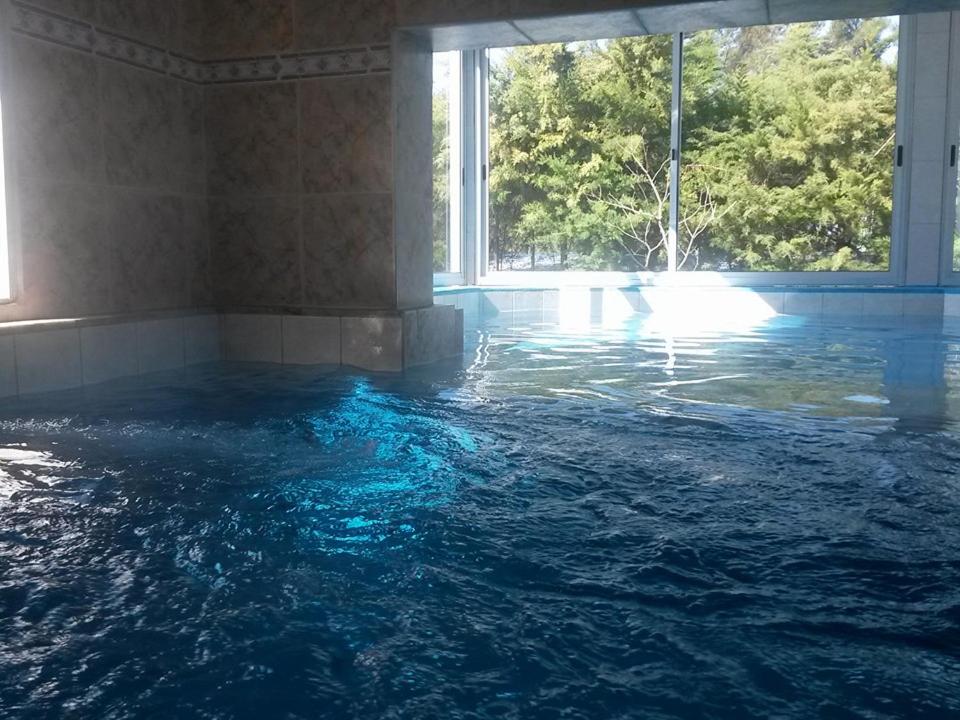 einen Pool mit Wasser in einem Zimmer mit Fenster in der Unterkunft Hotel La Posta del Dayman in Termas del Daymán