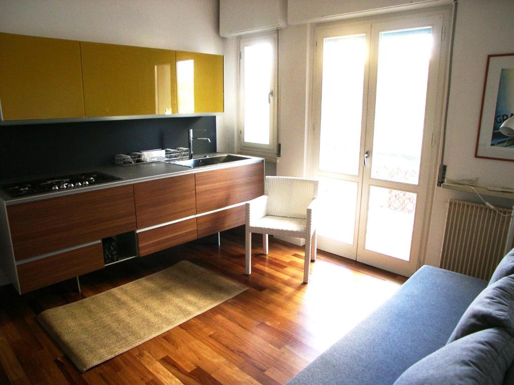 a living room with a kitchen with a couch and a table at Appartamento Dionea in Grado