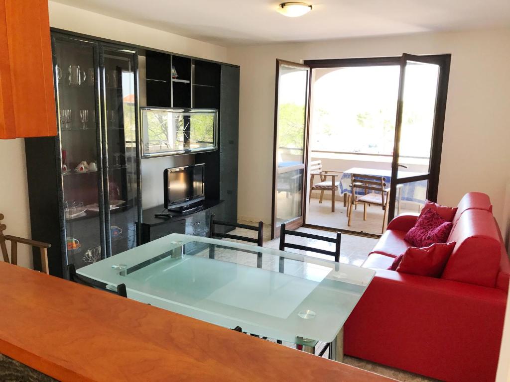 a living room with a red couch and a glass table at Villa Dora in Grado