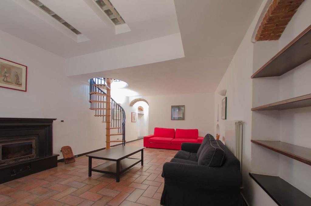 a living room with a red couch and a fireplace at Casa del Sole in Finale Ligure