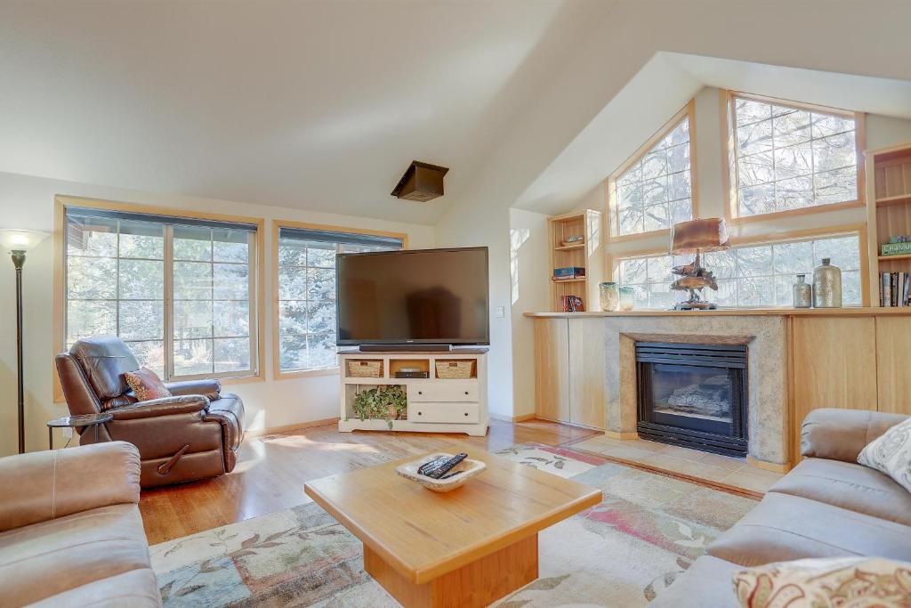 a living room with a tv and a fireplace at 13 Ollalie in Sunriver