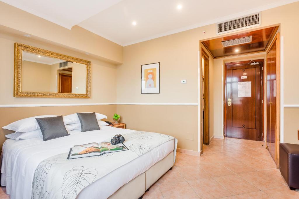 - une chambre avec un lit et un miroir dans l'établissement Raeli Hotel Archimede, à Rome