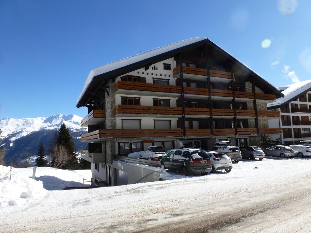 a large building with cars parked in a parking lot at IMMEUBLE Panorama in Les Collons