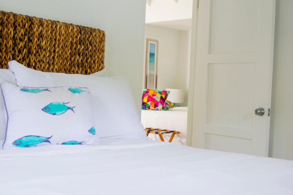 a white bed with fish on the pillows at Bequia Plantation Hotel in Bequia