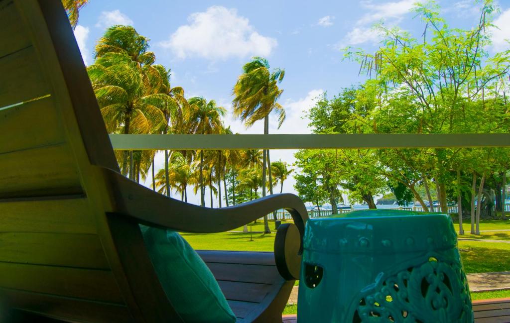 a bench in front of a window with palm trees at Bequia Plantation Hotel in Bequia