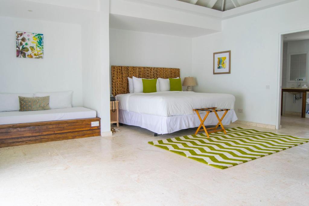 a bedroom with two beds and a rug at Bequia Plantation Hotel in Bequia
