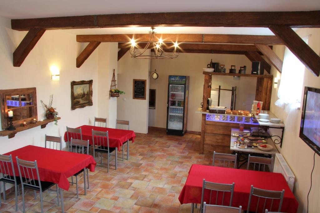een restaurant met rode tafels en stoelen in een kamer bij Eurobaltyk in Rewal