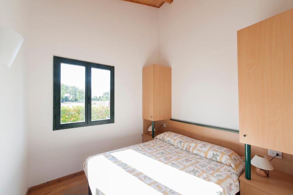 una camera da letto con un letto e una finestra di Settebello Village a Lido Di Fondi