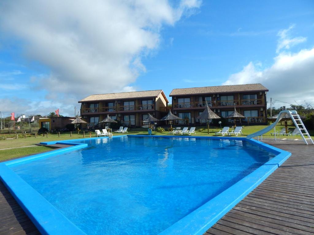 a large swimming pool in front of a resort at Sotavento Apart Hotel in La Paloma